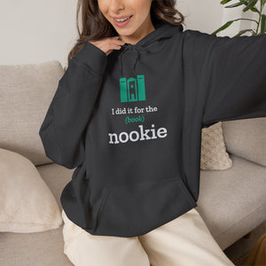 Woman on a couch wearing the dark heather grey Nook & Things hoodie