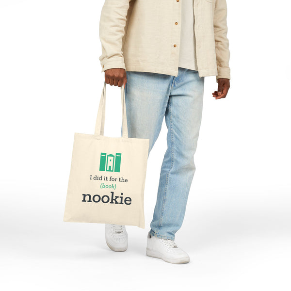 Natural canvas book tote carried at the side, hanging from the 20 inch handles