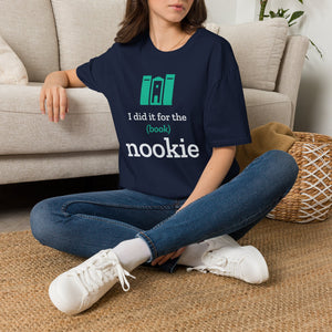 Woman sitting on the floor by a couch in the navy Nook & Things book nook t-shirt