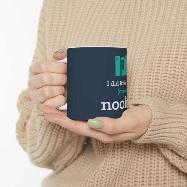 Hands in a cream sweater holding the navy Nook & Things bookish mug