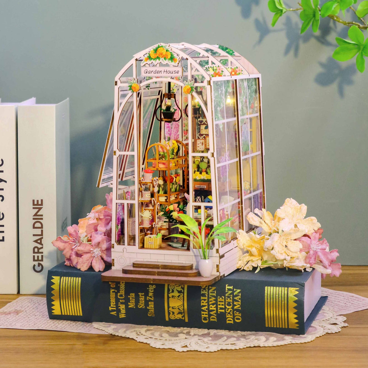 Nook & Things Garden House DIY book nook kit, tucked between books on a shelf