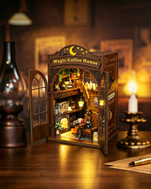 Nook & Things Magic Coffee House DIY book nook kit, on a desk with a lantern at night
