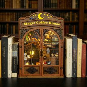 Nook & Things Magic Coffee House DIY book nook kit, tucked between books on a shelf