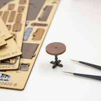 Nook & Things Magic Coffee House DIY book nook kit, pressing a piece out of the sheet with tweezers