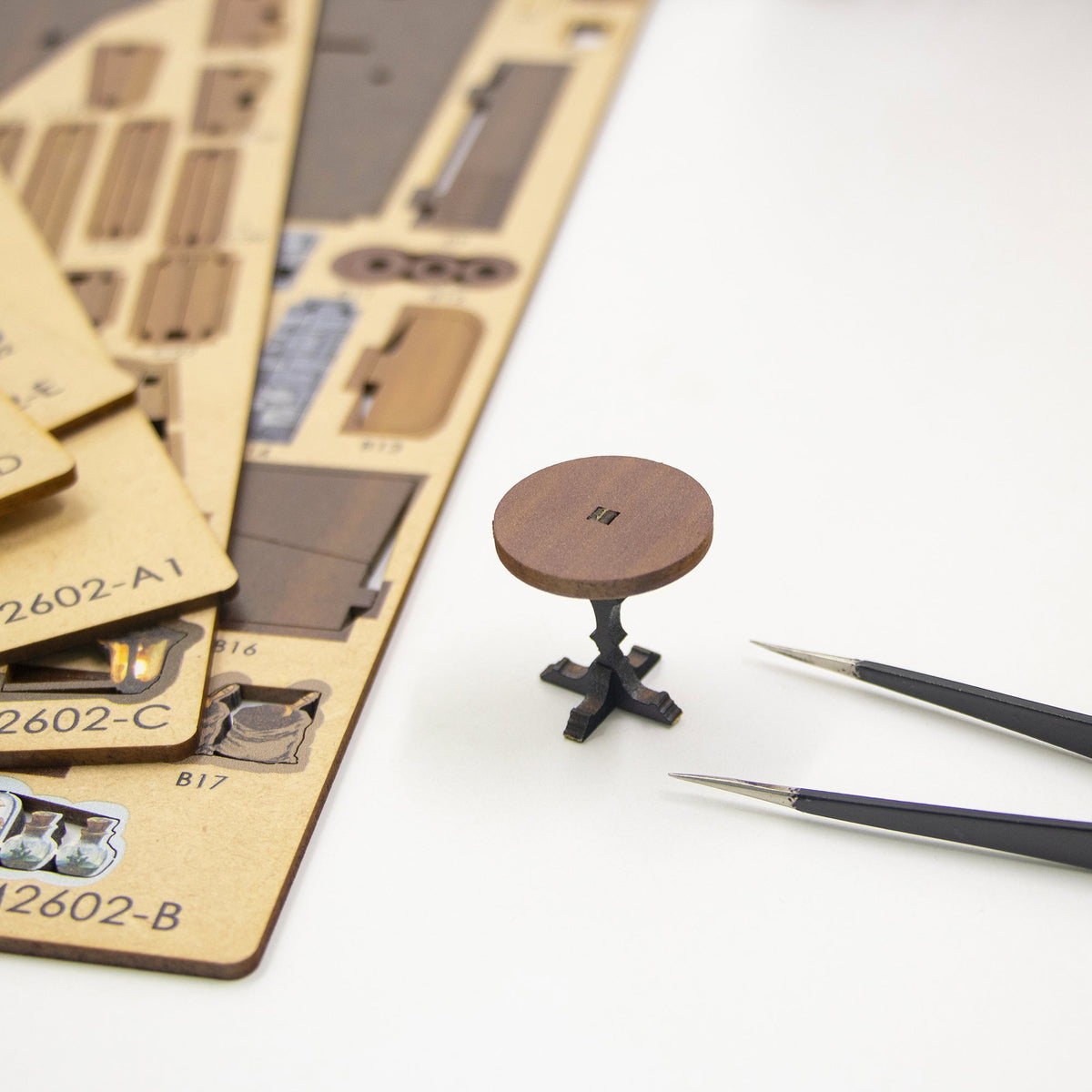 Nook & Things Magic Coffee House DIY book nook kit, pressing a piece out of the sheet with tweezers