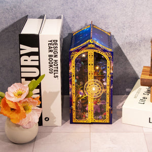 Nook & Things Magic Garden Workshop DIY miniature kit, tucked between books on a shelf
