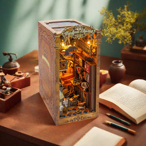 Nook & Things Magical Library DIY book nook kit, on a desk beside a lamp at night